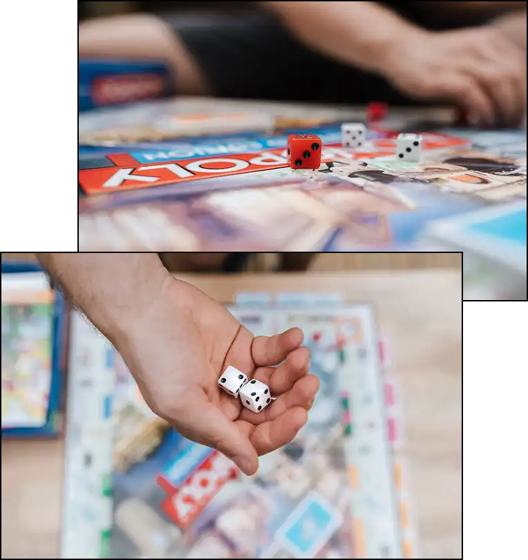 Kockadobás és Monopoly társasjáték közeli képe családi játék közben, kezekben dobókockák és színes játékelemek az asztalon.